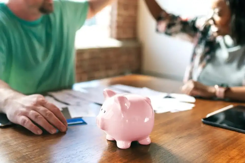 A couple going over their finances together in front of a piggy bank