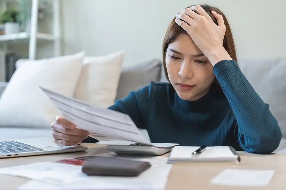 Woman looking over payday loan bills