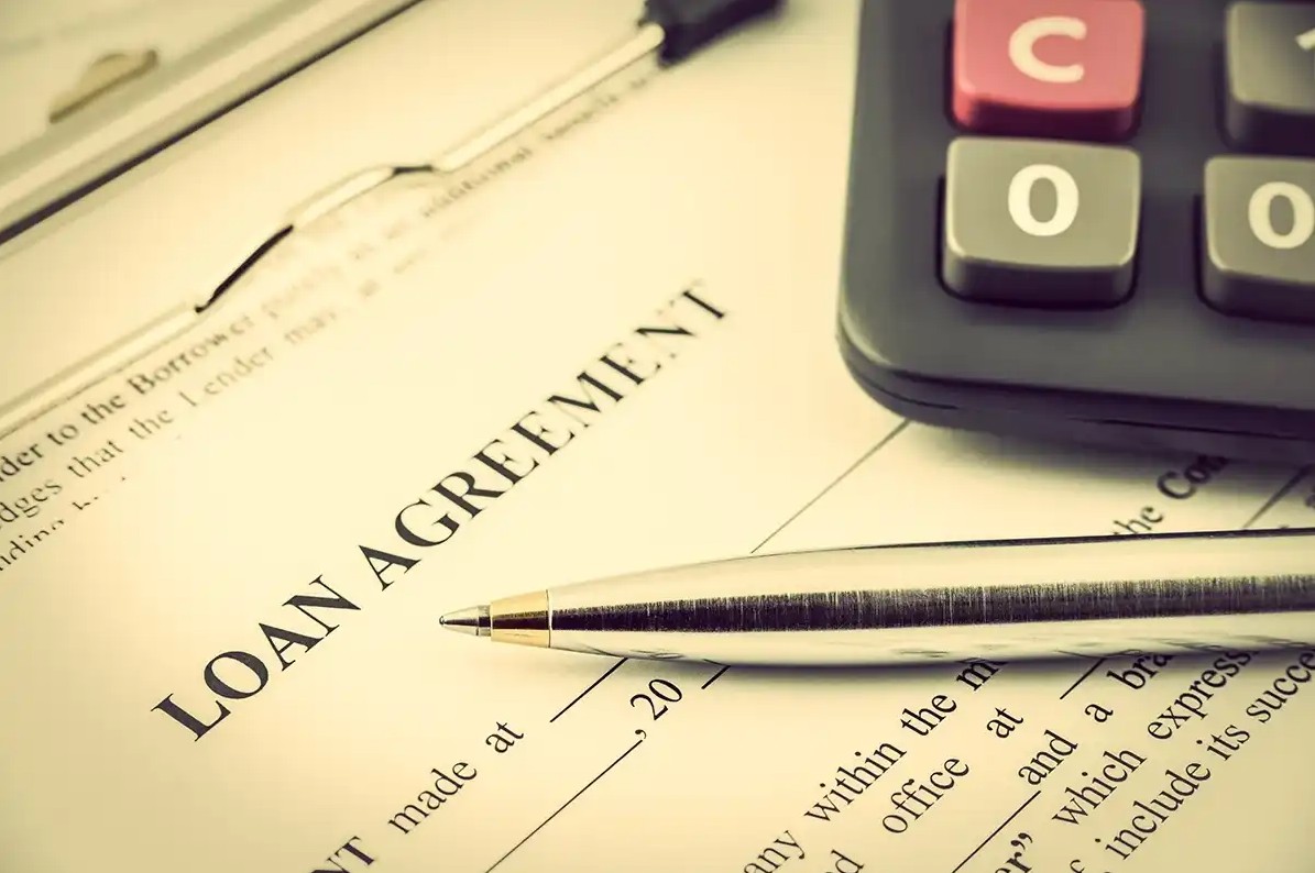 Loan agreement with pen and calculator on top
