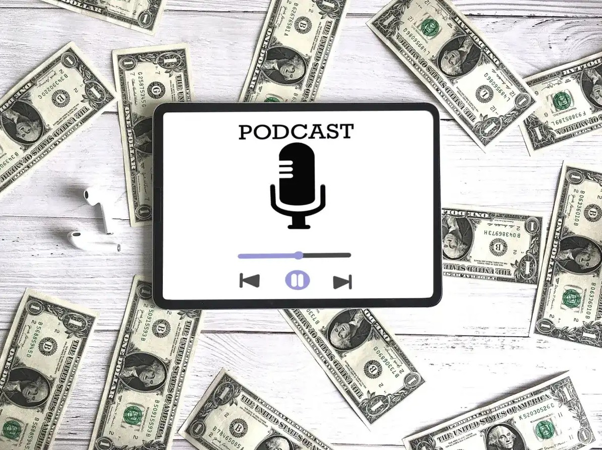 Podcast on tablet with money spread around