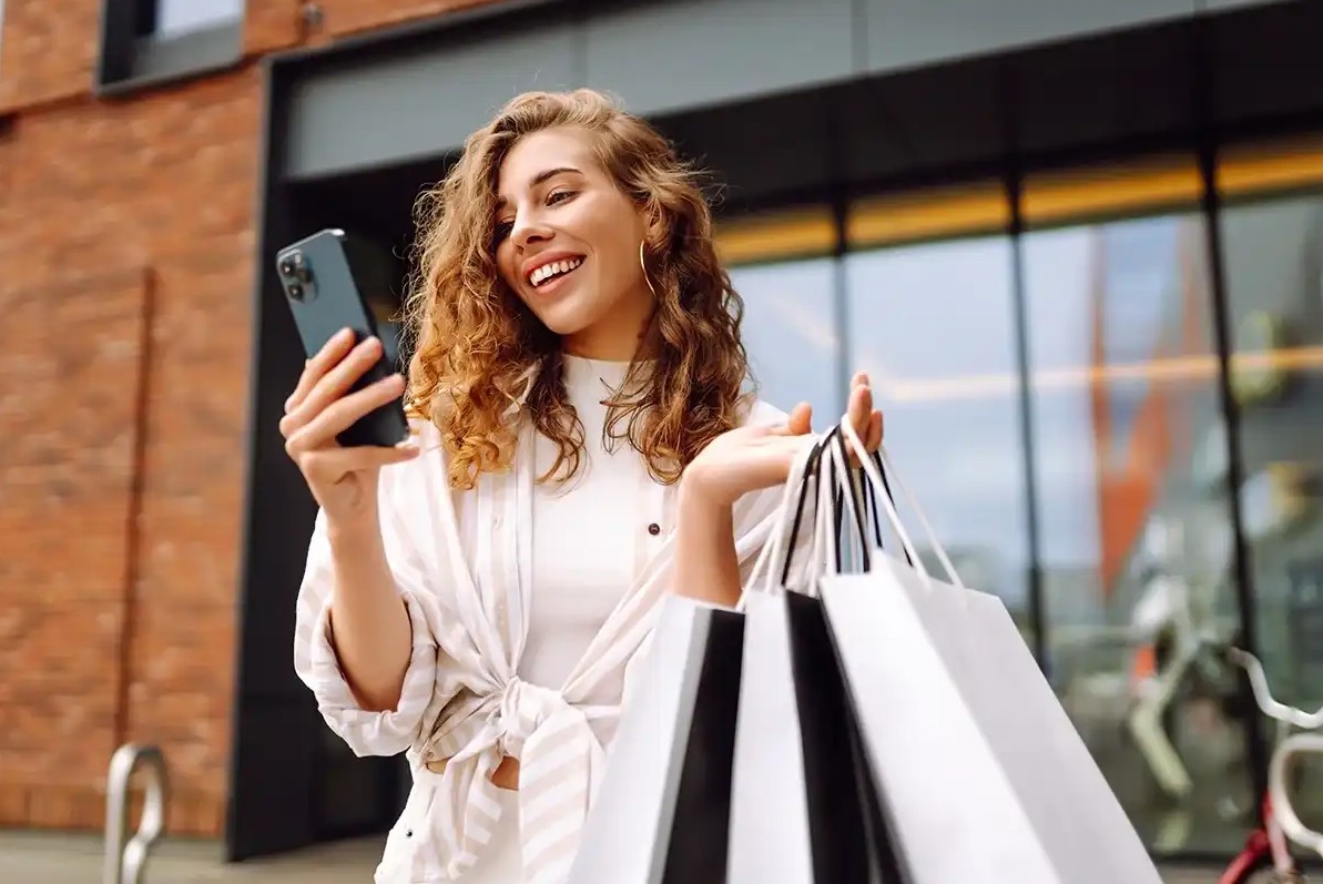 Woman checking her phone after shopping
