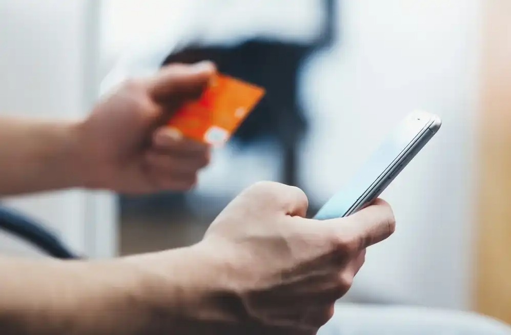 Someone using their credit card online on their phone