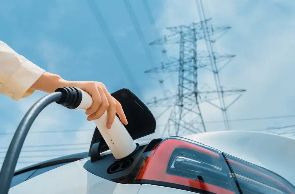 Person charging electric vehicle