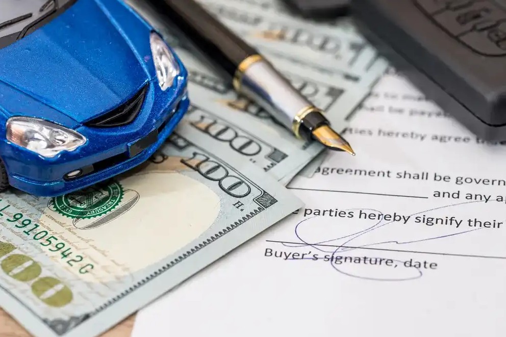 A toy car on top of loan paper